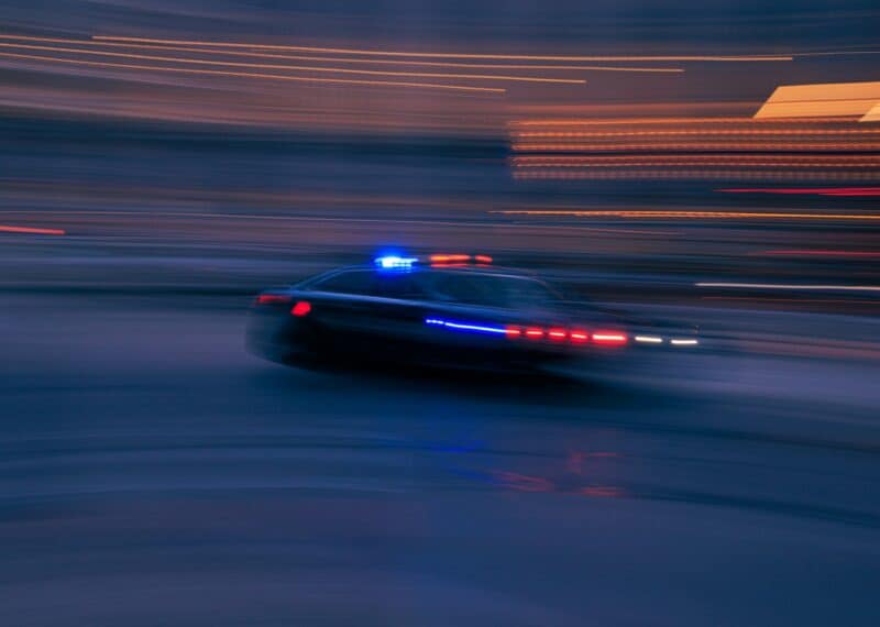 Alt text: Blurred police car lights, symbolising INTERPOL Red Notice and extradition proceedings in Bulgaria