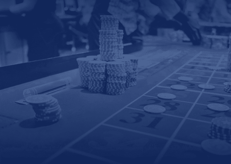 Gambling affiliate licence Bulgaria — roulette table with players placing bets, blue-toned casino image