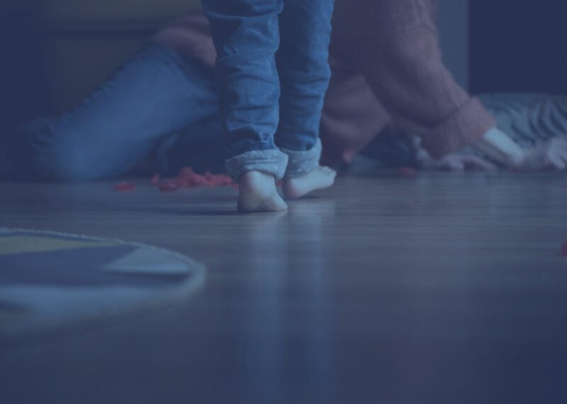 Child custody Bulgaria — child walking barefoot across a room toward a parent, blue-toned image